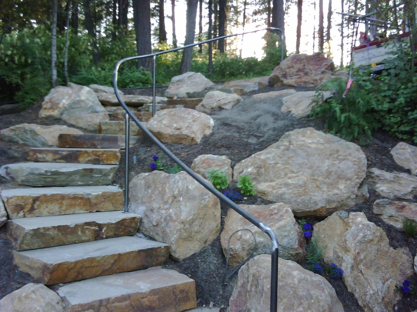 Rustic outdoor staircase with metal handrails and stone steps